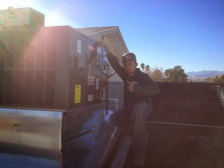 HVAC technician performing Heat Pump Repair on a rooftop unit in Eagle Point